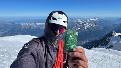 Kendal Mint Cake Energy Bar in hikers hand on top of a snowy mountain